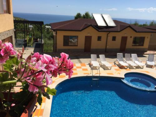 Una piscina en un patio con sillas y flores. en Complex Terazini, en Byala