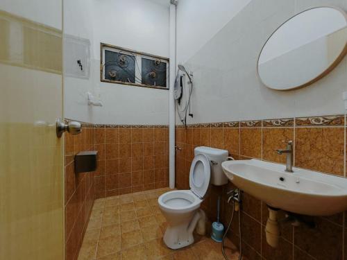 a bathroom with a sink and a toilet and a mirror at Private Pool KTV Family Villa 3R 12Pax by I Housing in Kampong Solok Haji Dollah