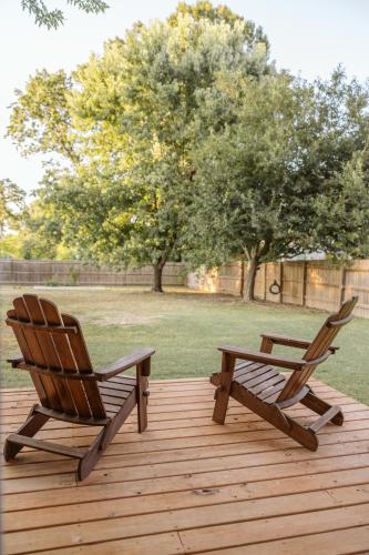 two chairs and a bench on a wooden deck at Downtown Bentonville The Cozy Switchback Entire Home with Biking and Trails Steps Away Including Hot Tub and Firepit in Bentonville