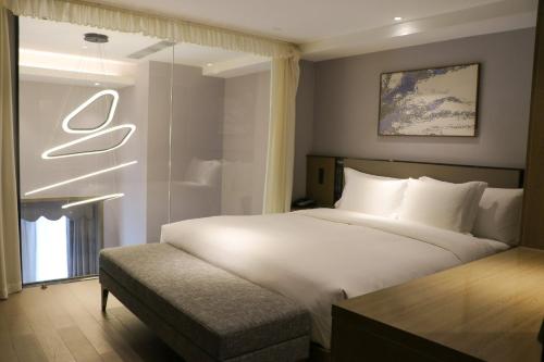 a bedroom with a large white bed and a window at Crowne Plaza Wuhan Development Zone by IHG in Wuhan
