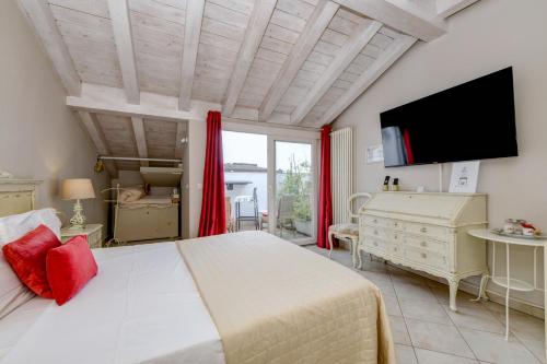 a bedroom with a large bed and a flat screen tv at Le Rêve - Lake view rooms in Sirmione
