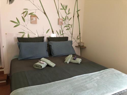 a bed with two pillows on top of it at La Pierrerie Bambou in Tourtour
