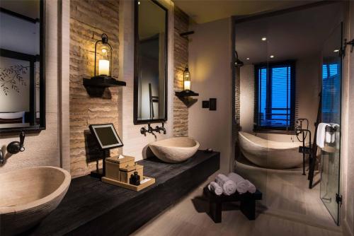 ein Badezimmer mit zwei Waschbecken und zwei Badewannen in der Unterkunft Alila Jabal Akhdar in Al Khuţaym