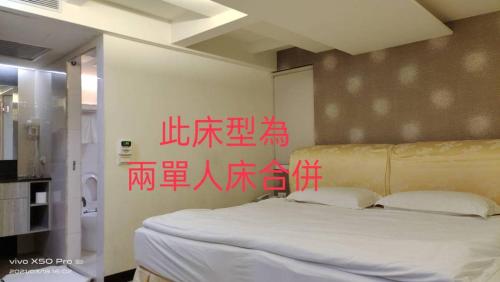 a bedroom with a bed with writing on the wall at 德瑞旅店Direct Hotel in Kaohsiung