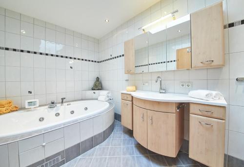 a bathroom with a tub and a sink at Appartements Der Fuchsbau in Saalbach Hinterglemm