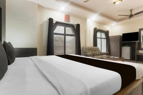 a bedroom with a white bed and a window at Townhouse Jabalpur Railway Junction Formerly Hotel Roopali in Jabalpur