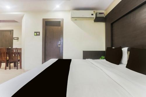 a bedroom with a bed with a black and white comforter at Townhouse Jabalpur Railway Junction Formerly Hotel Roopali in Jabalpur
