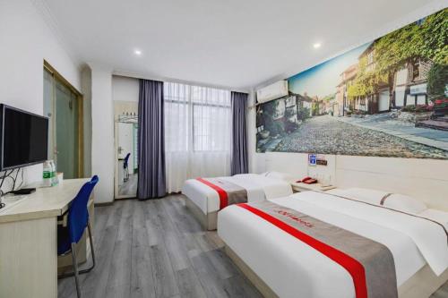 a hotel room with two beds and a tv at JUNYI Hotel Jiangxi Xinyu Baoshi Park in Xinyu