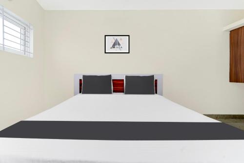 a bedroom with a large white bed with two pillows at Super Hotel O Avinashi Road Coimbatore in Coimbatore
