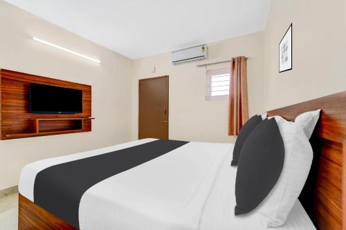 a bedroom with a large bed and a television at Super Hotel O Avinashi Road Coimbatore in Coimbatore