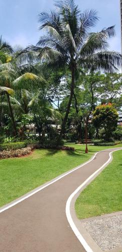 a winding path in a park with palm trees at Calm Lux 3 BR 2 Baths next to AEON Mall in Cilandak