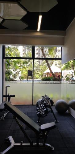 a gym with several treadmills and a large window at Calm Lux 3 BR 2 Baths next to AEON Mall in Cilandak
