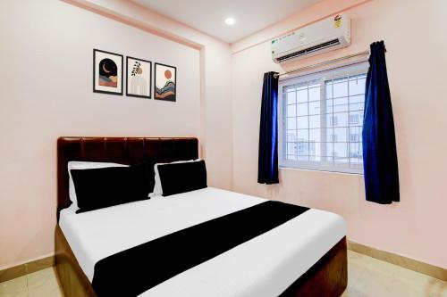 a bedroom with a bed and a window at Super Hotel O Chandanagar Formerly Nakshatra in Lingampalli