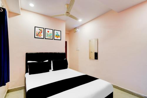 a bedroom with a black and white bed and a mirror at Super Hotel O Chandanagar Formerly Nakshatra in Lingampalli