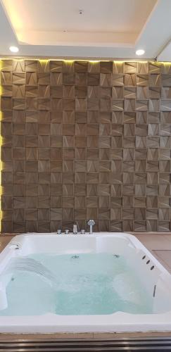 a large bath tub in a bathroom with a wall at Calm Lux 3 BR 2 Baths next to AEON Mall in Cilandak