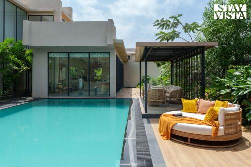 una villa con piscina frente a una casa en StayVista at Cielo House with Bonfire, Pool, en Alibaug