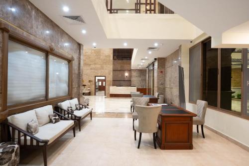 a lobby with couches and a table and chairs at Treetop by Eight Continents, Zanzibar in Mchangani