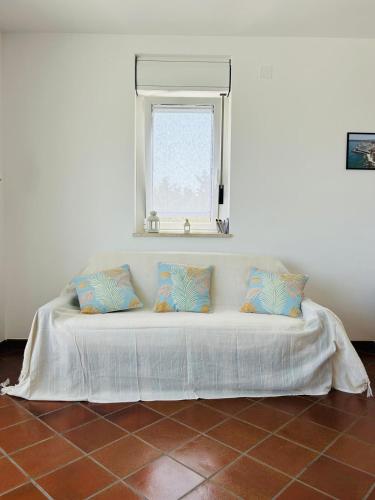 a bed with two pillows sitting under a window at Terrazza Dolce Vista in Monopoli