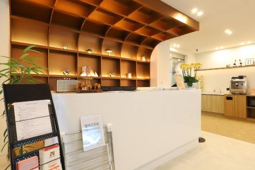 a large kitchen with a counter and a counter top at JB Plus Hotel in Busan