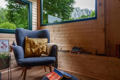 a blue chair in a room with a window at Mountain Retreat Stars Peak in Bačić Duliba