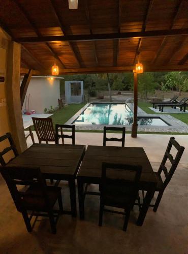 a dining area with a table and chairs and a pool at Aaryana Lagoon in Tangalle