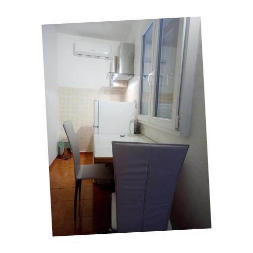 a kitchen with a table and two chairs at inKorcula in Korčula