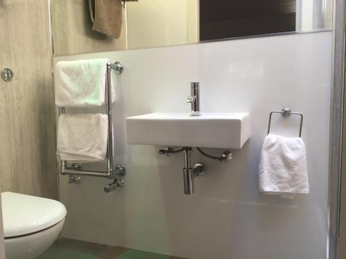 a white bathroom with a sink and a toilet at Irvine Bay in Irvine