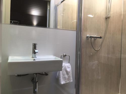 a bathroom with a sink and a shower with a mirror at Irvine Bay in Irvine