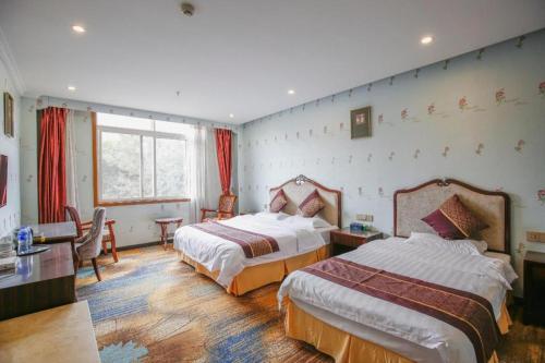 une chambre d'hôtel avec deux lits et une fenêtre dans l'établissement yiantaisheng hotel co ltd, à Wangsiying