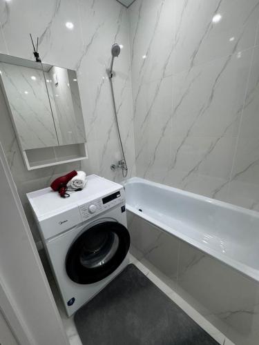 Un baño blanco con inodoro y bañera. en Апартамент, en Uralsk