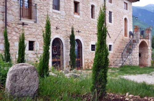 a stone building with trees in front of it at B&B Casal Cominium in San Donato Val di Comino