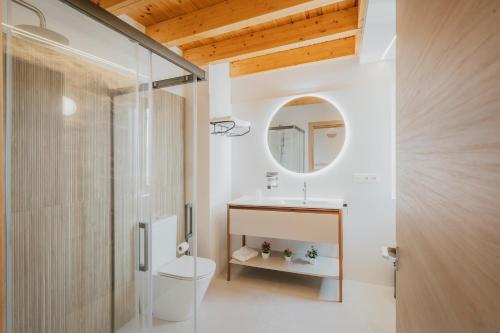 a bathroom with a toilet and a sink and a mirror at Casa Rural Vallehermoso 