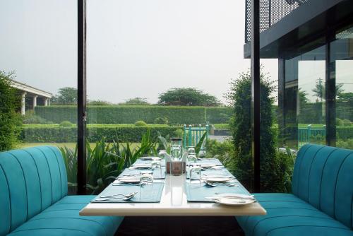 a table with blue chairs sitting on a patio at TreeHouse Velis Sonipat in Sonīpat