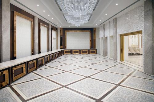 a lobby with a large tiled floor and a chandelier at TreeHouse Velis Sonipat in Sonīpat