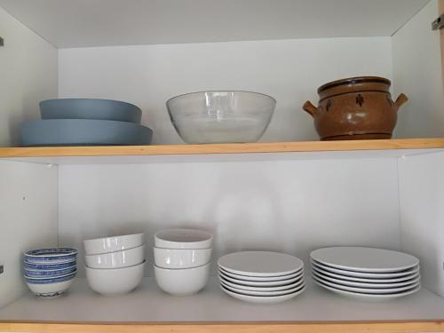a shelf with plates and bowls and a pot at Faré blue lagoon in Moorea
