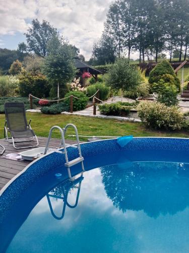 a swimming pool with a chair next to a swimming pool at Agroturystyka pod Baranią Gorą in Kamesznica