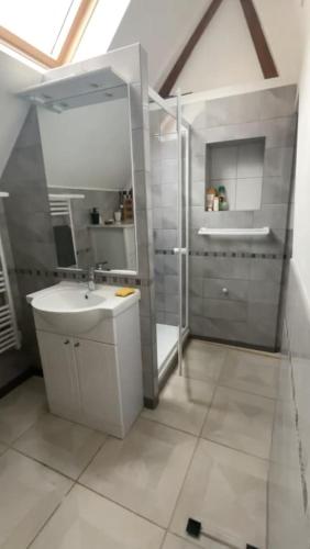 a white bathroom with a sink and a shower at loft à la campagne in Vermenton