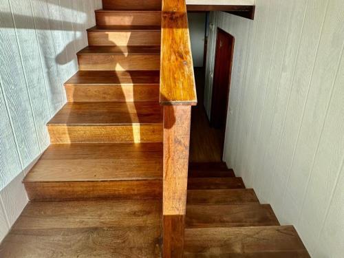 a wooden staircase with a wooden handrail in a house at Faré blue lagoon in Moorea