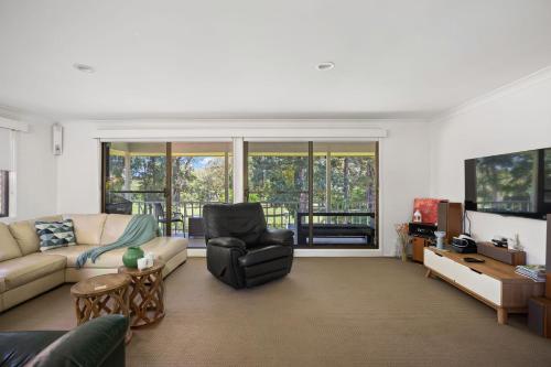 a living room with a couch and a chair at Ocean & Golf in Mollymook
