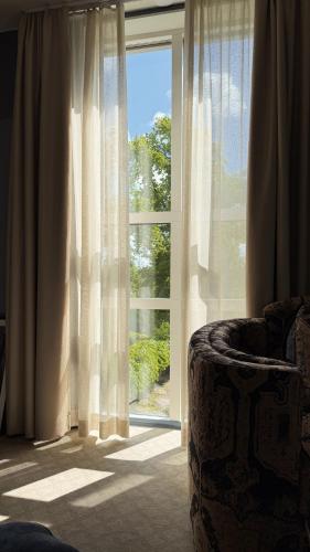 a room with a window with a chair in front of it at Karstorp Säteri – Hotell och Konferens in Skövde