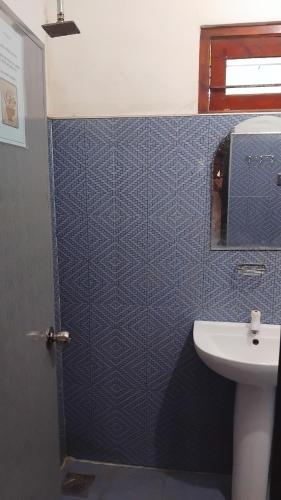 a blue tiled bathroom with a sink and a toilet at Punkalasa tourist lodge in Anuradhapura