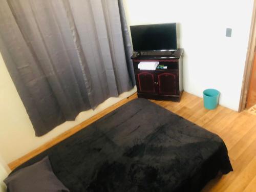 a bedroom with a bed and a desk with a television at Hotelito Ejido de la 10 in Puebla