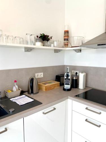 a kitchen with white cabinets and a counter top at Apartmentkombi Eltville für bis zu 8 Personen in Eltville