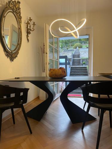 a black table with a mirror and chairs in a room at Schönste Location in Würzburg in Würzburg