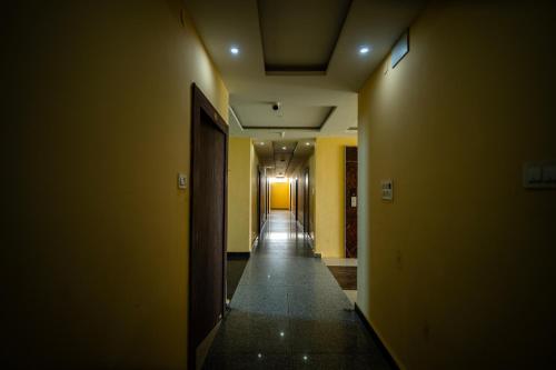 an empty hallway with yellow walls and a hallwayngthngthngthngthngthngthngth at Hotel The Royal Buddha in Bodh Gaya