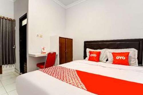 een slaapkamer met een groot bed met rode kussens bij OYO 94756 '23 Residence in Kejayan