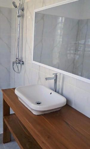 a white sink on a wooden counter in a bathroom at Wind & Sea Lakey Peak in Huu