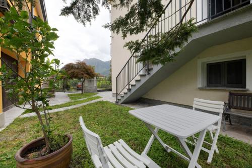 a white table and chairs in a yard with a tree at La Villa di Ludo in San Cassiano