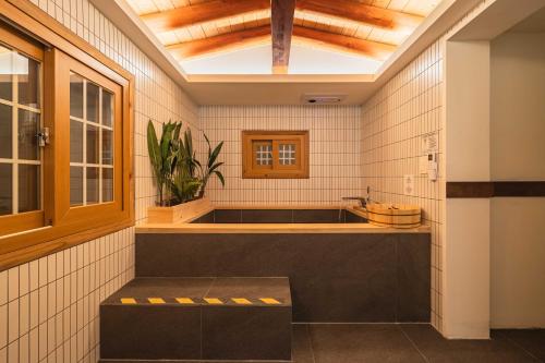 a bathroom with a bath tub and a sink at Luxury Hanok Garden Retreat in Incheon