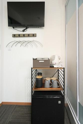 a small black refrigerator with a tv on the wall at NAMBA STAY 302 新今宮 Shiimamiya in Osaka